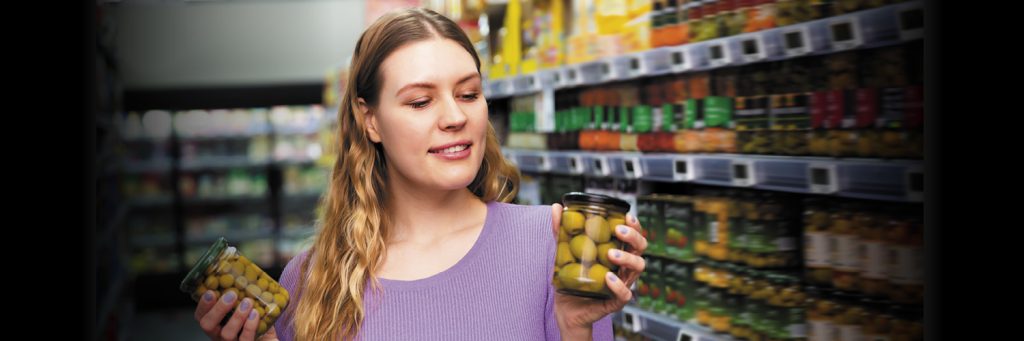 shopper holds glass olive jars